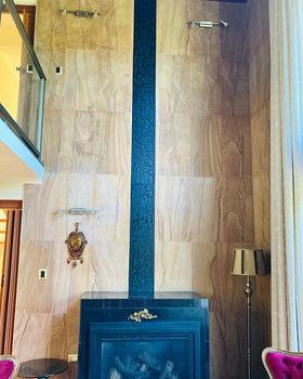 Protección tubo de chimenea, celosía para reja hoyo muro ventilación chimenea, tipo columna decorativa de acero, con silueta de copihues en vertical diseño orgánico, acero tipo calado troquelado, instalada en salón de living decoración clásica, testimonio cliente, diseñado y fabricada a medida por IronPig Chile