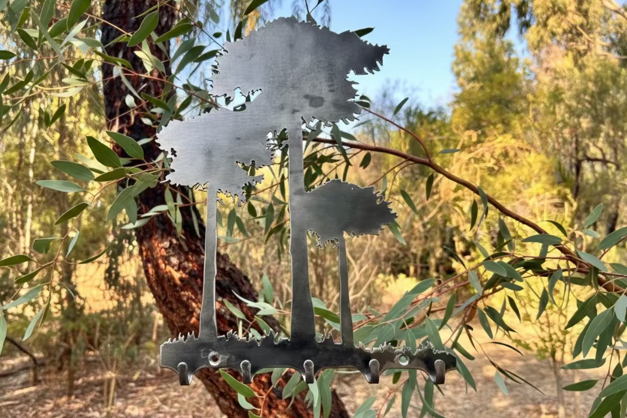 Perchero funcional que cumple la doble funcion de decorar con su silueta de arboles de araucarias y sostener con sus ganchos para siempre tus cosas.
