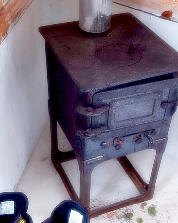 Estufa a leña, tamaño mediano, diseñada para calentar espacios en interior, posee tapa para cocina y tiraje para que prenda rápido. Hecha en Chile por IronPig. Foto de cliente caso real experiencia testimonio
