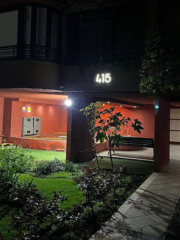 Foto de cliente y testimonio de compra producto número tipo caja para retroiluminar, letrero instalado en Edificio Jardines de Suecia, comuna de Providencia, Santiago, Región Metropolitana. Detalle que incluyó el cliente mica blanca detrás de la numeración. Hecho por IronPig en Chile 