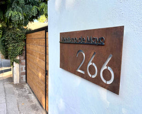 Letrero de acero con nombre de calle y numeracion acabado oxidado encerado hecho por IronPig foto de cliente letrero instalado testimonio real Santiago Región Metropolitana