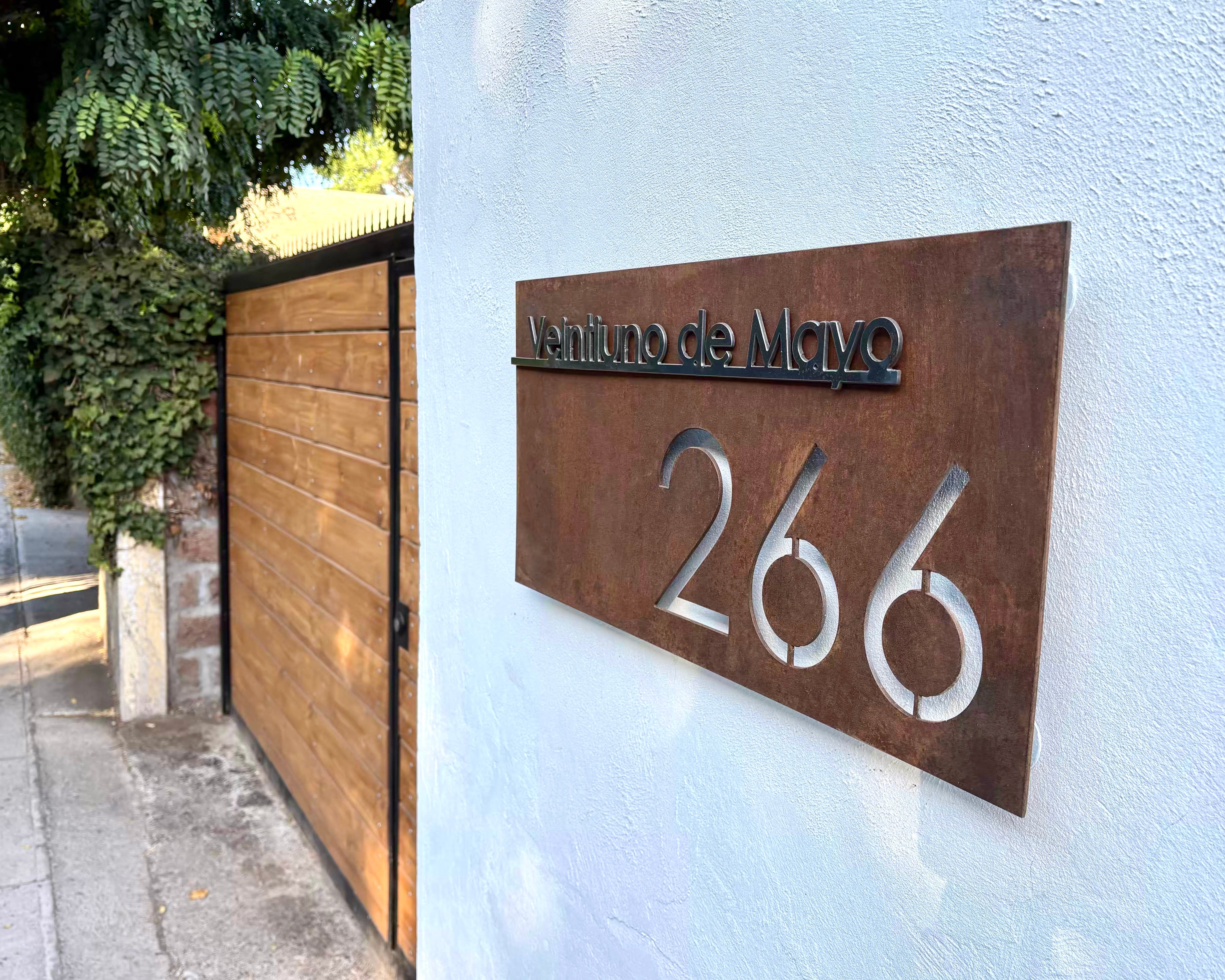 Letrero de acero con nombre de calle y numeracion acabado oxidado encerado hecho por IronPig foto de cliente letrero instalado testimonio real Santiago Región Metropolitana