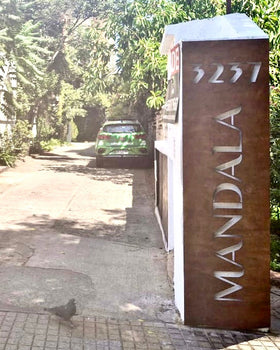 Numeración residencial y letrero de acero corten con letras caladas instalado en entrada de edificio Mandala 5237, Santiago – IronPig